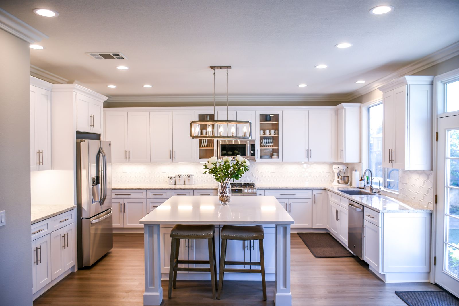 Remodeled white kitchen with a center island, quartz counters, and subway tile