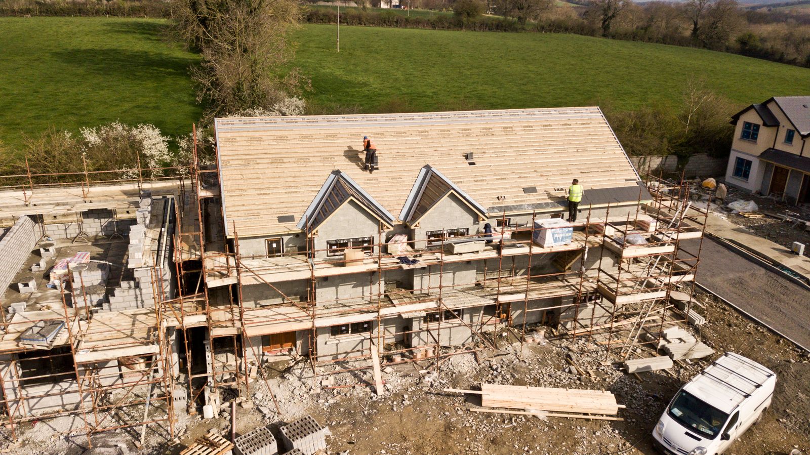 Roofers installing roofing on a house under construction